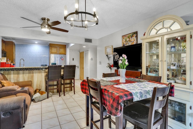 dining room with a chandelier, a textured ceiling, ceiling fan, and light tile patterned flooring