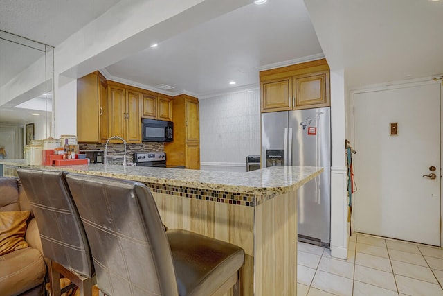 kitchen featuring stainless steel appliances, a peninsula, light tile patterned floors, light stone counters, and backsplash