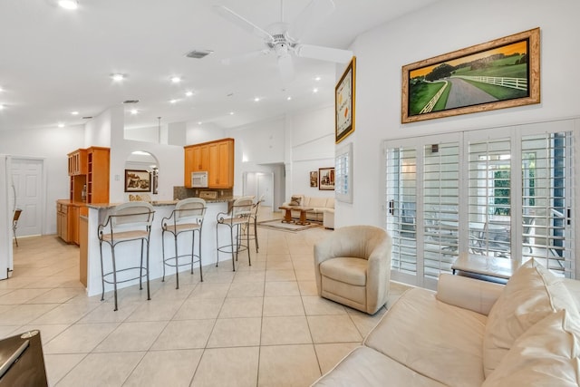 7315 Falls Rd E, Boynton Beach, FL 33437 - kitchen featuring white fridge with ice dispenser, light tile patterned floors, a ceiling fan, visible vents, and a breakfast bar area