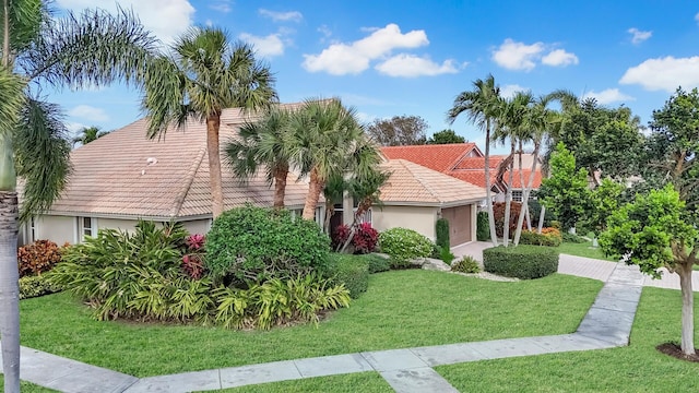 7315 Falls Rd E, Boynton Beach, FL 33437 - view of front facade featuring a tiled roof, a garage, stucco siding, and a front lawn
