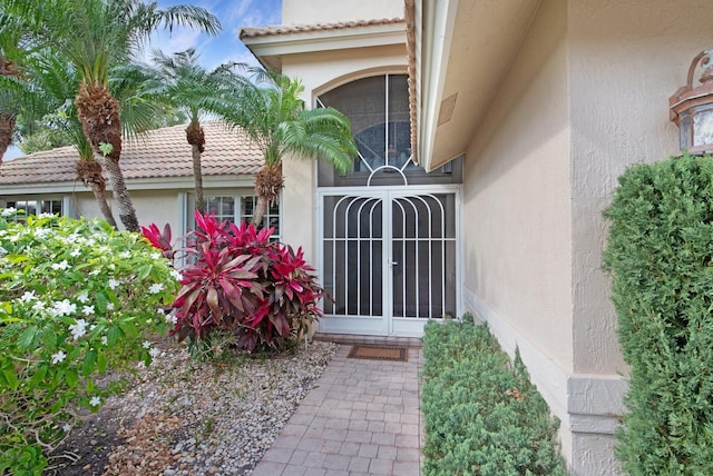 7315 Falls Rd E, Boynton Beach, FL 33437 - view of front of house featuring a tiled roof, a garage, stucco siding, and a front lawn