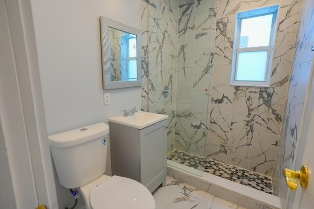 bathroom with marble finish floor, a tile shower, toilet, and vanity
