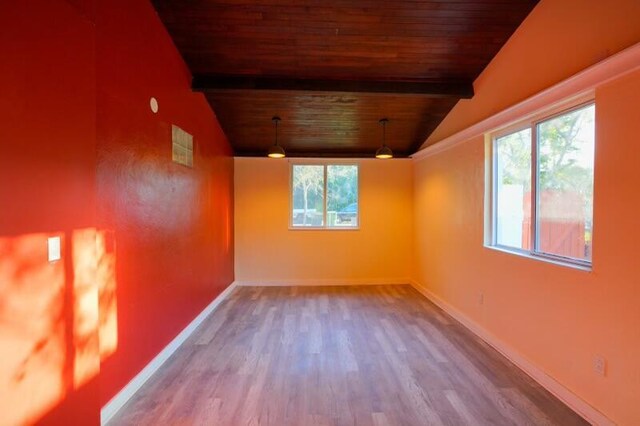 spare room featuring wood ceiling, lofted ceiling with beams, and baseboards