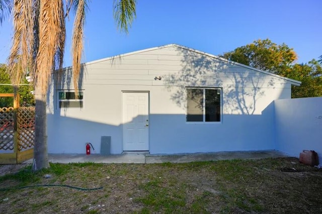 back of property featuring stucco siding and fence
