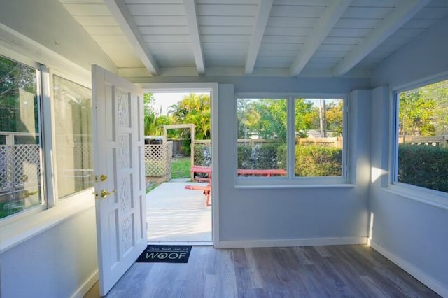 doorway featuring baseboards, vaulted ceiling with beams, and wood finished floors