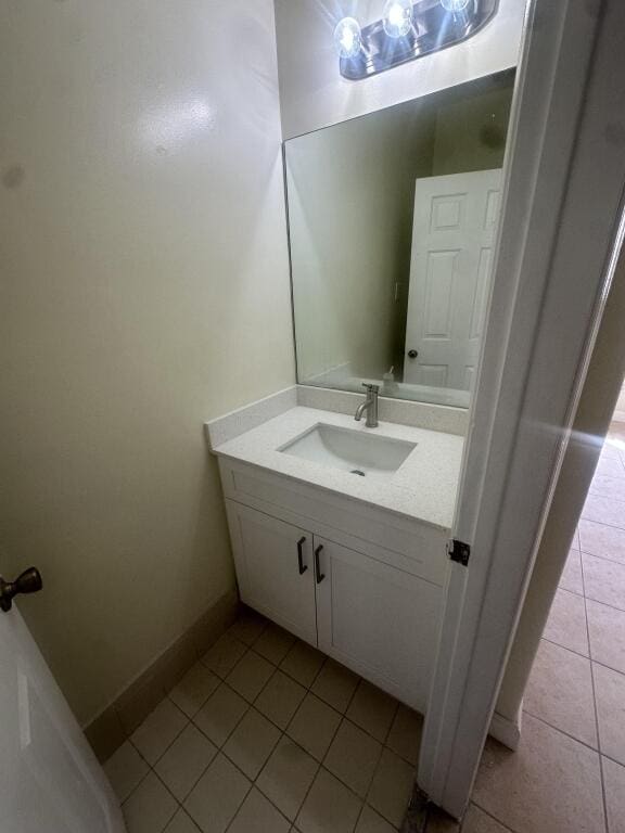 bathroom with baseboards, tile patterned flooring, and vanity