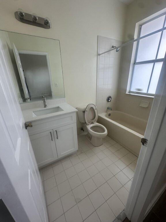 bathroom with tile patterned floors,  shower combination, toilet, and vanity