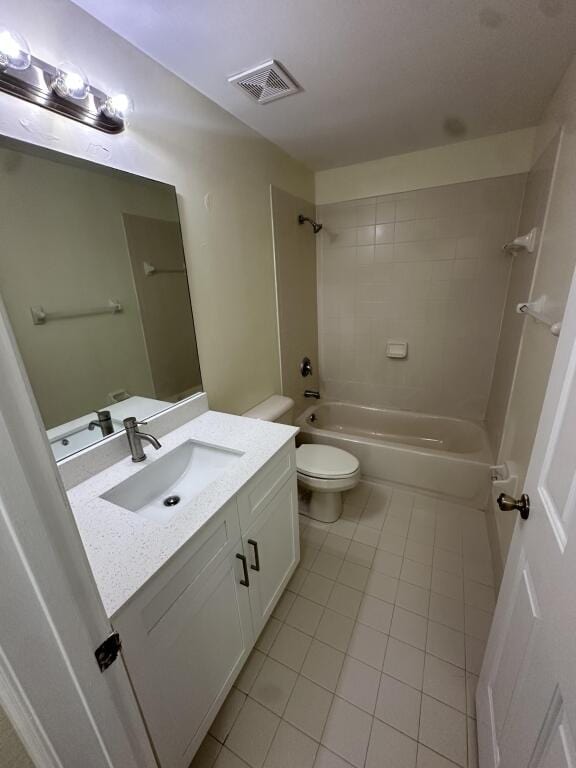 bathroom with visible vents, washtub / shower combination, toilet, vanity, and tile patterned flooring