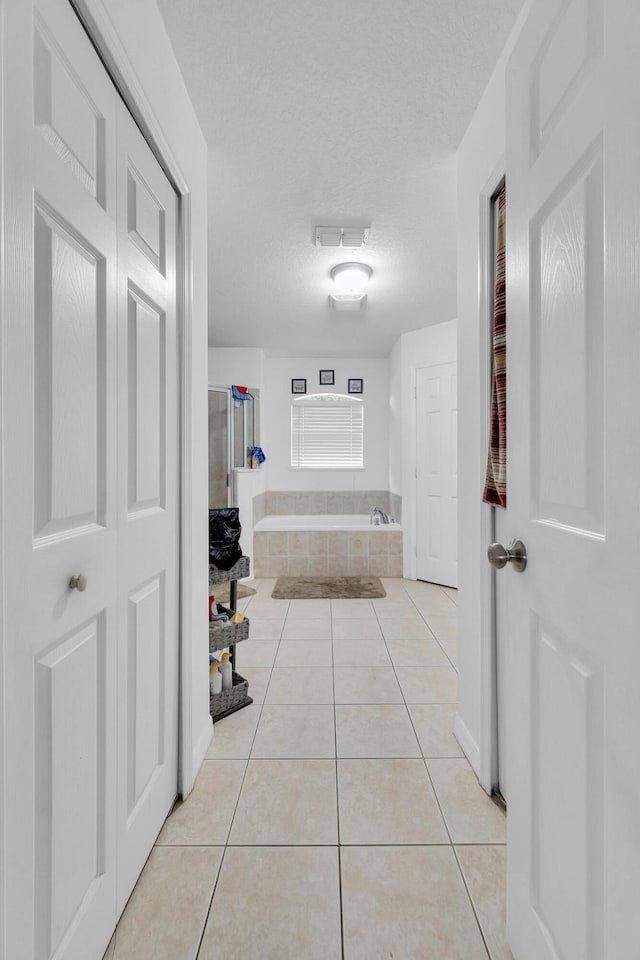 6116 NW Daroco Ter, Port Saint Lucie, FL 34986 - hallway with a textured ceiling, visible vents, and light tile patterned floors