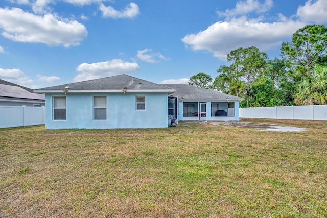6116 NW Daroco Ter, Port Saint Lucie, FL 34986 - back of property featuring a sunroom, a fenced backyard, a lawn, and stucco siding