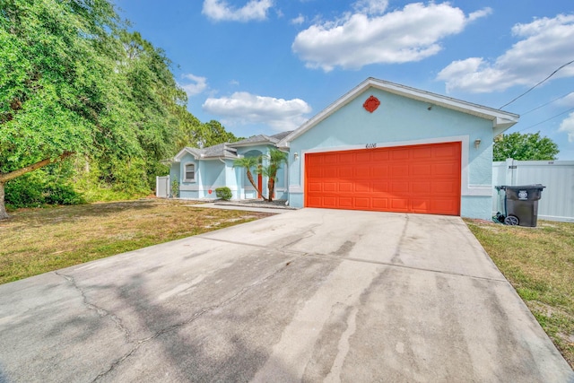 6116 NW Daroco Ter, Port Saint Lucie, FL 34986 - ranch-style home with fence, a garage, stucco siding, a front yard, and driveway