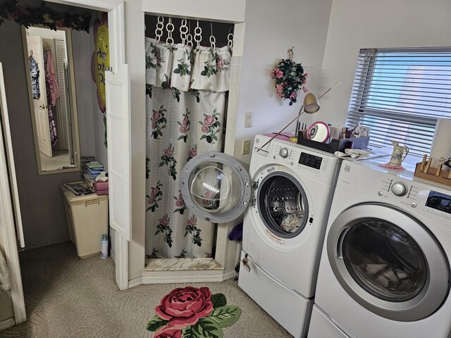 clothes washing area featuring laundry area, washer and dryer, and light colored carpet