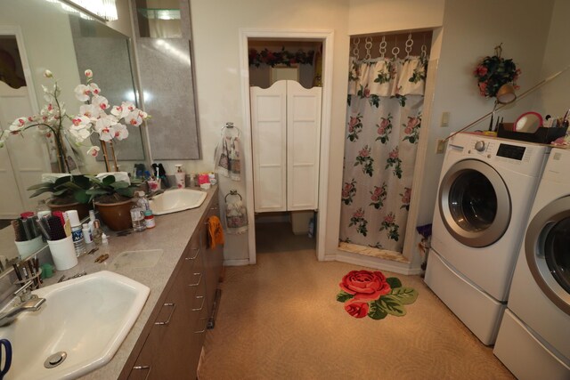 bathroom with a sink, washer and dryer, and a shower stall