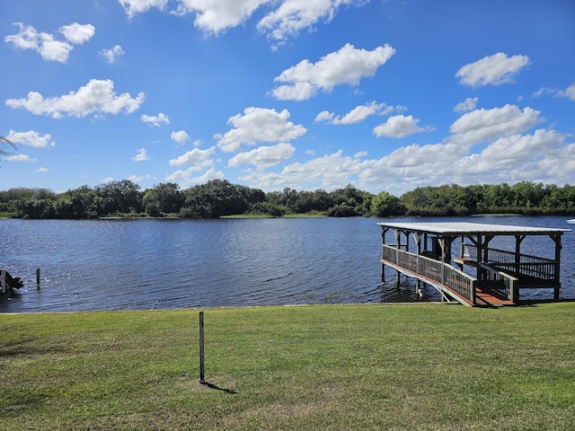 view of dock featuring a water view and a yard