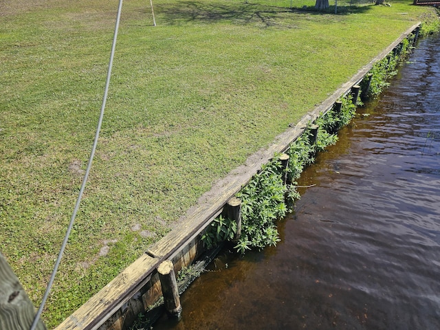dock area with a water view and a yard