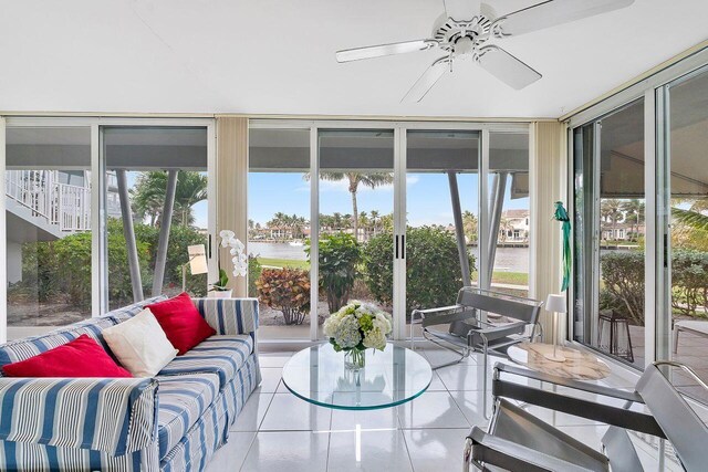 sunroom / solarium with floor to ceiling windows, a ceiling fan, an outdoor hangout area, and tile patterned flooring