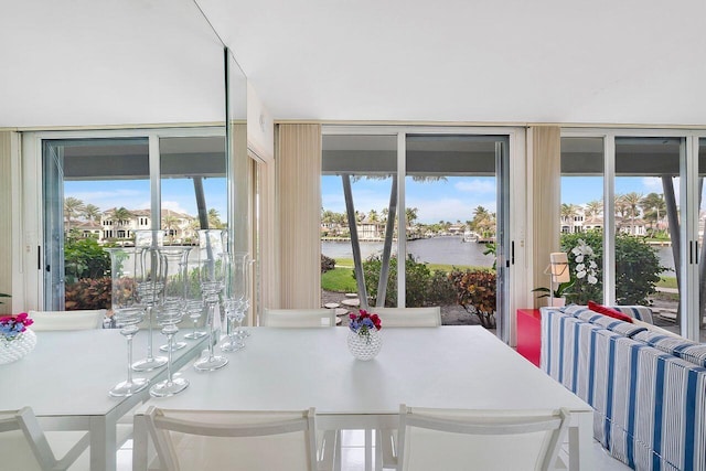 dining space with a water view, radiator heating unit, and a healthy amount of sunlight
