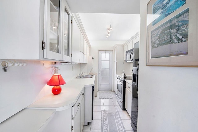 kitchen with light countertops, a sink, black microwave, white cabinetry, and stainless steel electric stove