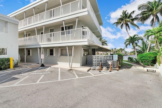 view of property with uncovered parking and central AC