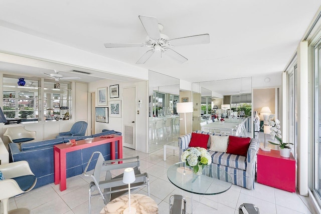 living area with light tile patterned floors, visible vents, and ceiling fan