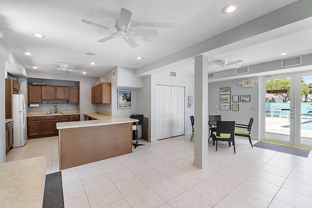 kitchen with freestanding refrigerator, light countertops, visible vents, and ceiling fan