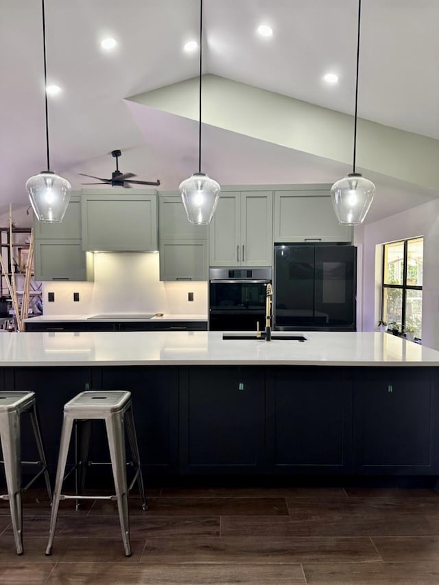9494 Sun Pointe Dr, Boynton Beach, FL 33437 - kitchen featuring black fridge, a sink, vaulted ceiling, light countertops, and a large island