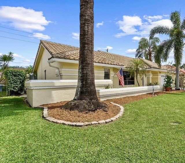 9494 Sun Pointe Dr, Boynton Beach, FL 33437 - view of front of house featuring stucco siding, a tile roof, and a front lawn