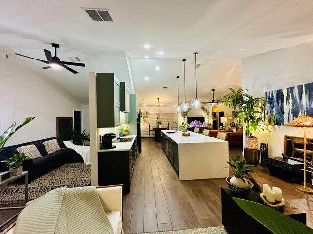 9494 Sun Pointe Dr, Boynton Beach, FL 33437 - kitchen with open floor plan, ceiling fan, light countertops, wood finished floors, and dark cabinets