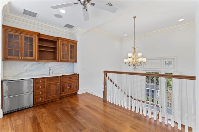 kitchen with brown cabinetry, open shelves, ornamental molding, glass insert cabinets, and dark wood-style floors