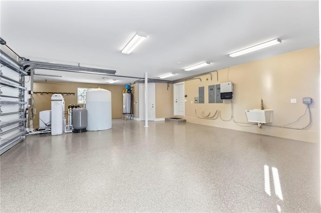 garage with a sink, gas water heater, and electric panel