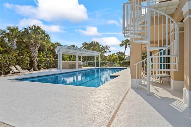 view of swimming pool with a fenced in pool, stairs, a patio area, and a pergola