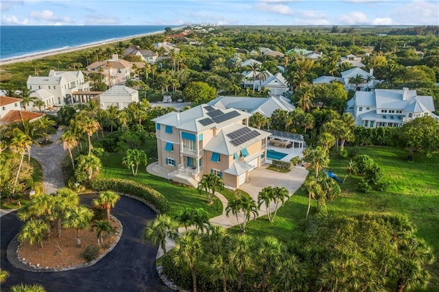 drone / aerial view featuring a beach view, a water view, and a residential view