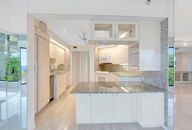4605 S Ocean Blvd Unit 4C, Highland Beach, FL 33487 - kitchen featuring white appliances, a peninsula, backsplash, and plenty of natural light