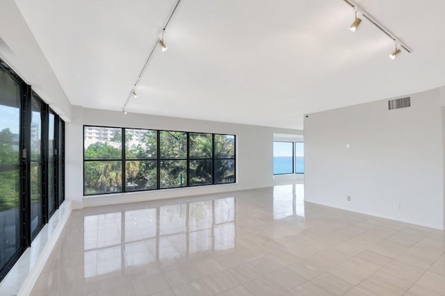 4605 S Ocean Blvd Unit 4C, Highland Beach, FL 33487 - spare room featuring rail lighting, light tile patterned floors, and baseboards