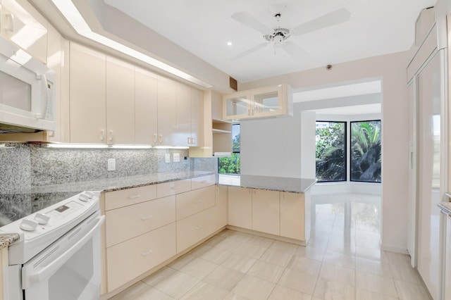 4605 S Ocean Blvd Unit 4C, Highland Beach, FL 33487 - kitchen with white appliances, tasteful backsplash, a peninsula, a ceiling fan, and light stone countertops