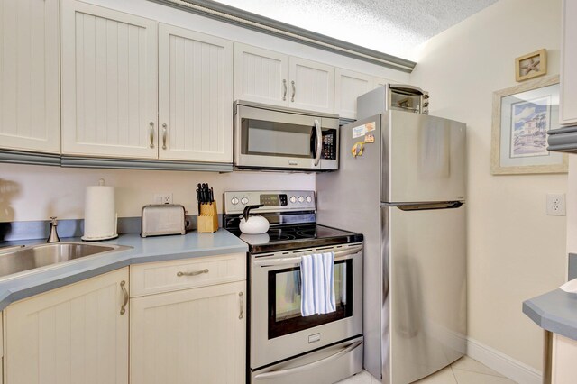 4468 NE Ocean Blvd Unit G2, Jensen Beach, FL 34957 - kitchen featuring appliances with stainless steel finishes, a sink, light tile patterned floors, baseboards, and light countertops