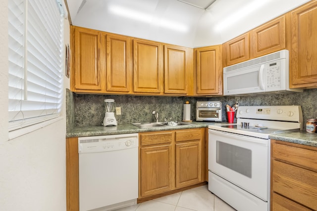 325 Tilford P, Deerfield Beach, FL 33442 - kitchen featuring white appliances, backsplash, a sink, light tile patterned flooring, and brown cabinetry