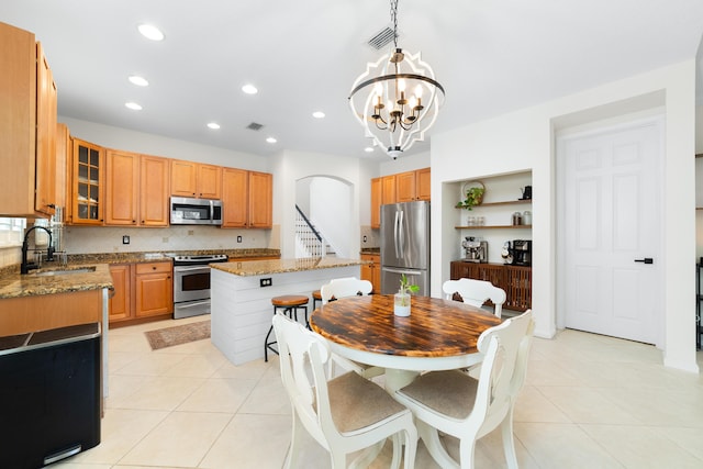 kitchen with light tile patterned flooring, a sink, a chandelier, and appliances with stainless steel finishes