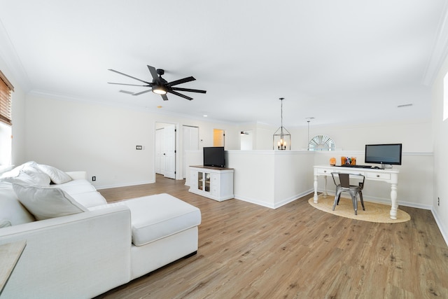 living room with light wood finished floors, baseboards, ornamental molding, and a ceiling fan