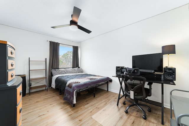 bedroom featuring a ceiling fan, light wood-style flooring, and baseboards