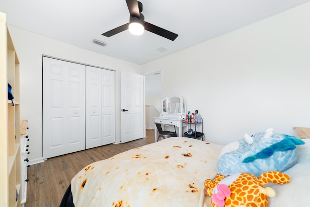 bedroom with a ceiling fan, wood finished floors, a closet, and visible vents