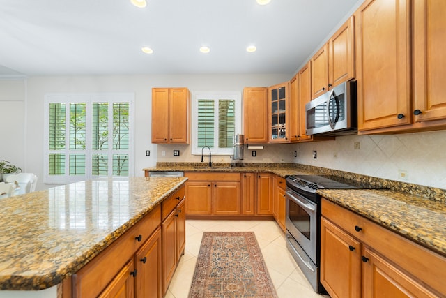 kitchen featuring stone counters, appliances with stainless steel finishes, light tile patterned floors, decorative backsplash, and recessed lighting