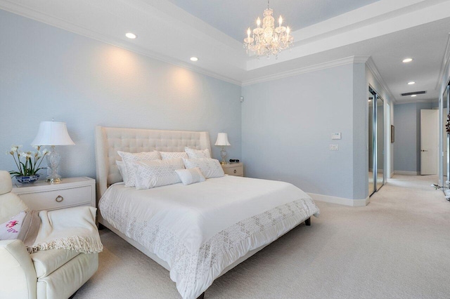 bedroom with a tray ceiling, an inviting chandelier, ornamental molding, and light colored carpet