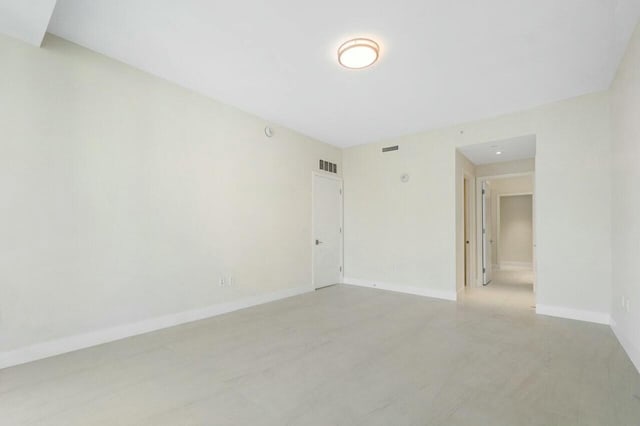 empty room with baseboards and visible vents