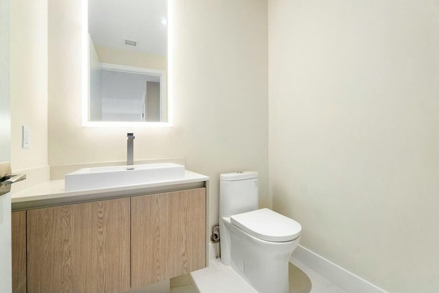 bathroom with baseboards, visible vents, toilet, and vanity