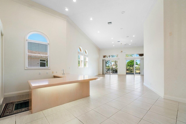 kitchen featuring baseboards, crown molding, and light tile patterned floors