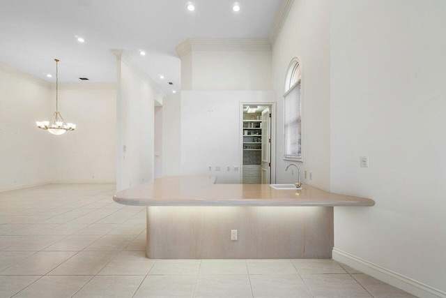 kitchen featuring crown molding, recessed lighting, light tile patterned floors, baseboards, and a sink