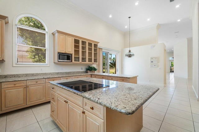kitchen with crown molding, a center island, black electric cooktop, built in microwave, and light brown cabinets