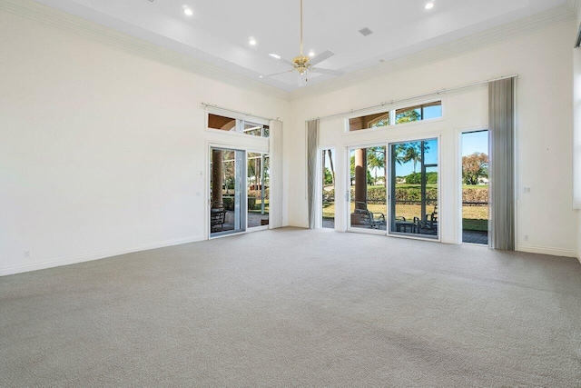 carpeted empty room featuring crown molding, recessed lighting, baseboards, a high ceiling, and a ceiling fan