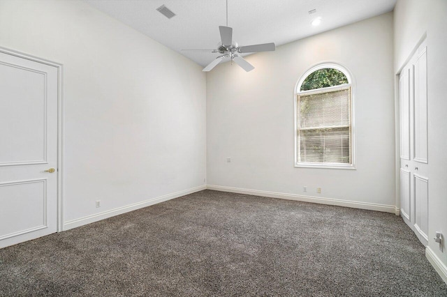 carpeted empty room with baseboards, a textured ceiling, ceiling fan, and visible vents
